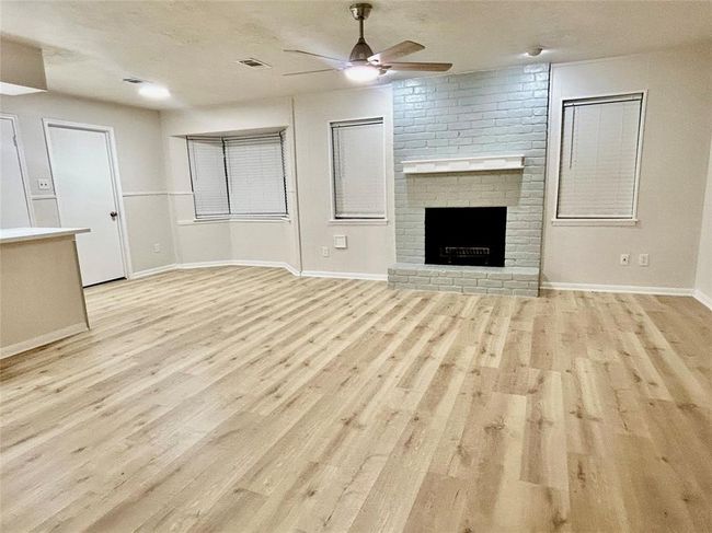 Open living area offering woodburning fireplace | Image 17