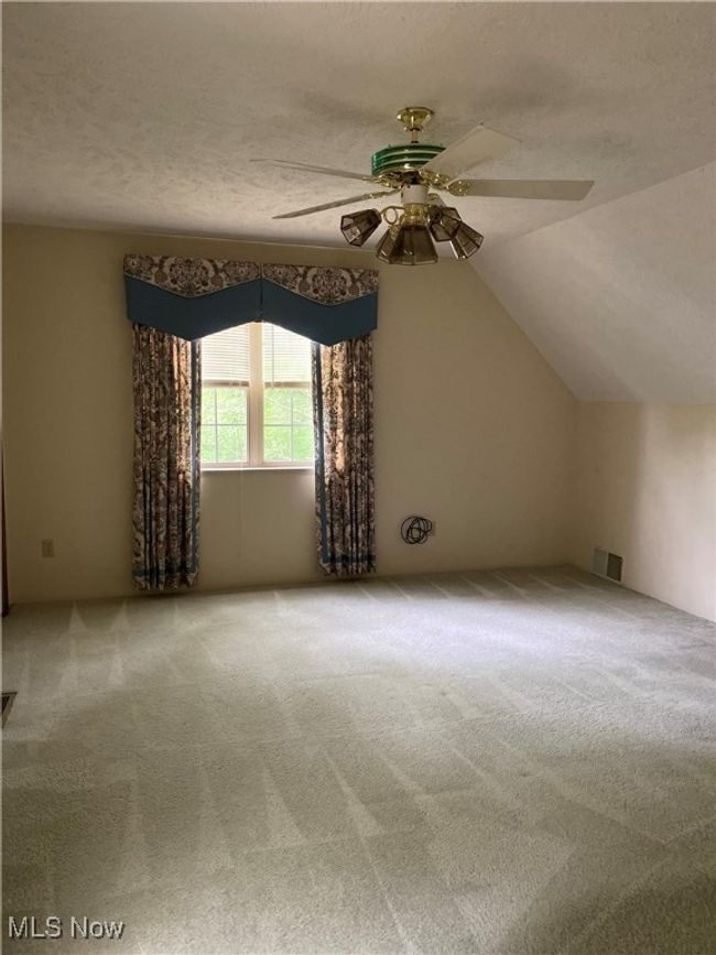 Additional living space with a ceiling fan, carpet flooring, a textured ceiling, and vaulted ceiling | Image 13