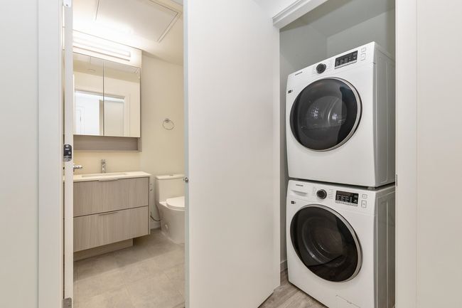 Laundry room with estacked washer and dryer and light tile patterned floors | Image 13