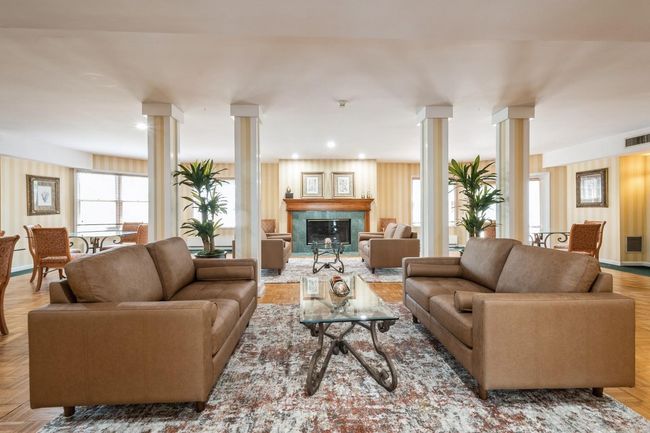 Community room with decorative columns and a premium fireplace | Image 22