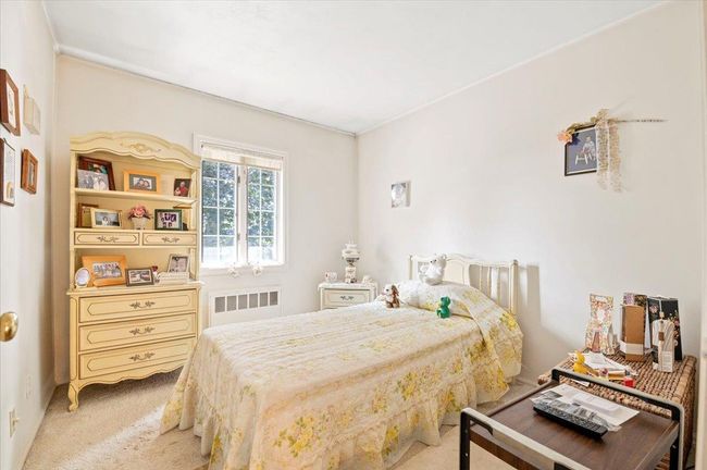 Bedroom with radiator heating unit and light carpet | Image 16