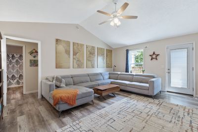 The living room features a calming neutral paint scheme, complemented by sleek laminate flooring and a ceiling fan. 2803 Black Stallion Ct Murfreesboro, TN 37130 | Image 2