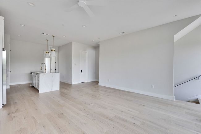 Unfurnished living room featuring a sink, a ceiling fan, baseboards, light wood-type flooring, and recessed lighting | Image 21
