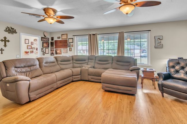Living area featuring a ceiling fan and light wood-type flooring | Image 7