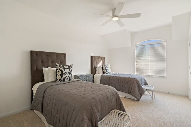 Bedroom featuring a ceiling fan, lofted ceiling, baseboards, and light colored carpet | Image 18