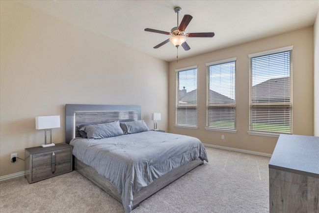 Bedroom featuring light carpet, baseboards, and ceiling fan | Image 15
