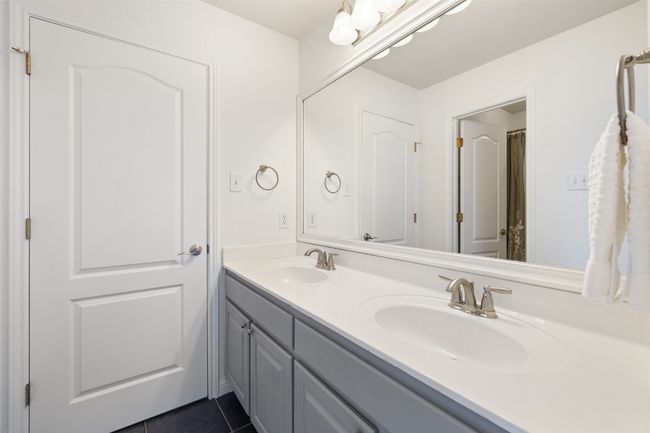 Bathroom featuring a sink and dark tile patterned flooring | Image 30