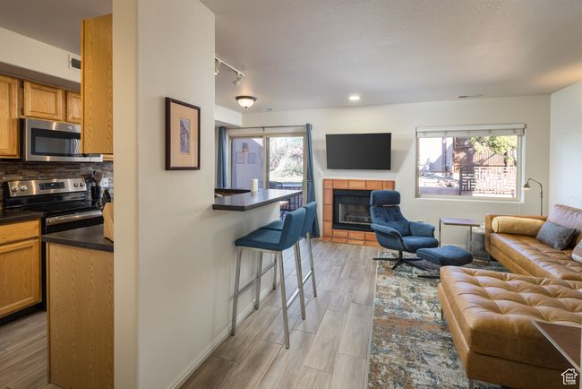 Living room featuring a tile fireplace, light wood-type flooring, and track lighting | Image 11