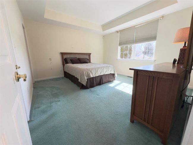 Primary 1st floor Bedroom featuring baseboards and a tray ceiling | Image 7