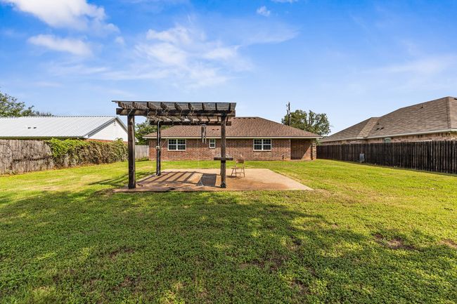 Fenced backyard featuring a pergola and a patio | Image 11