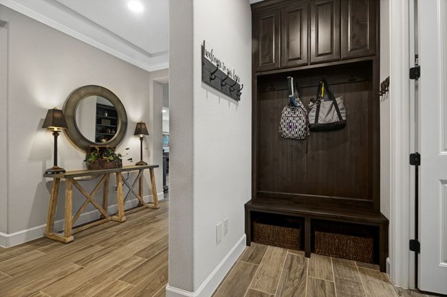 Mudroom featuring light wood-style floors, crown molding, and baseboards | Image 5