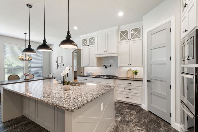 Kitchen with stainless steel appliances, a sink, recessed lighting, decorative backsplash, and an island with sink | Image 9