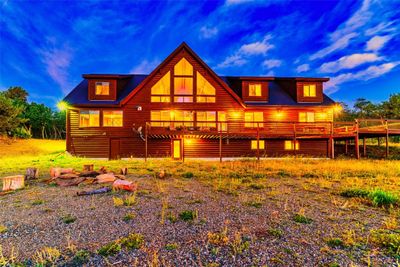 Back house at dusk with a wooden deck | Image 1