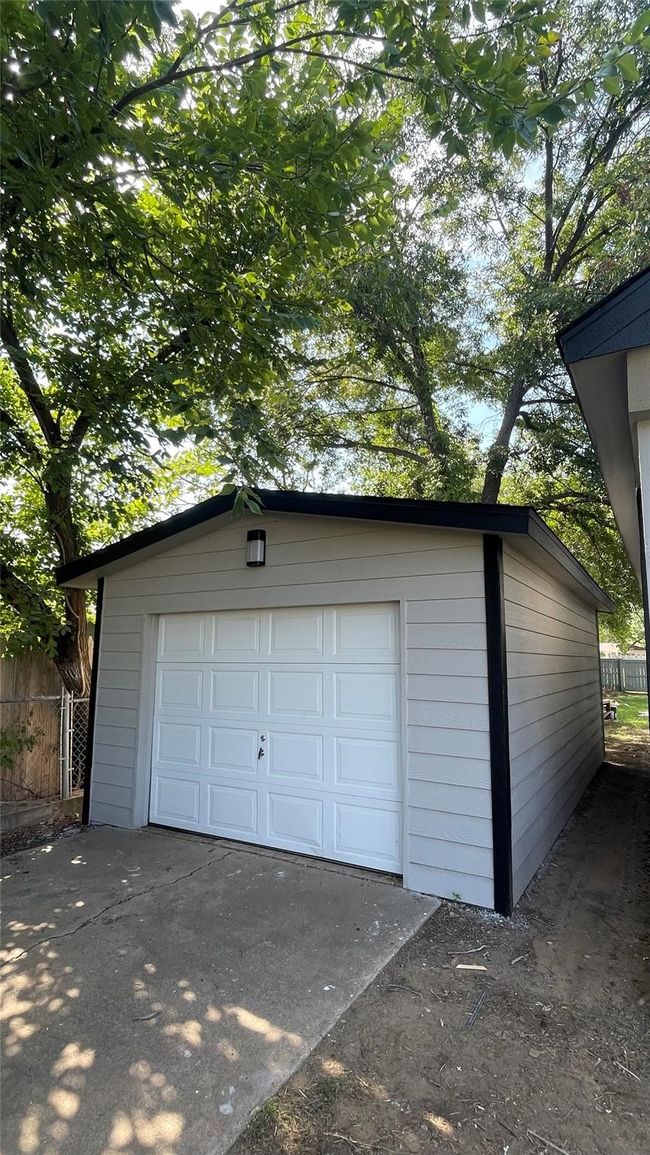 Detached garage with concrete driveway and fence | Image 7
