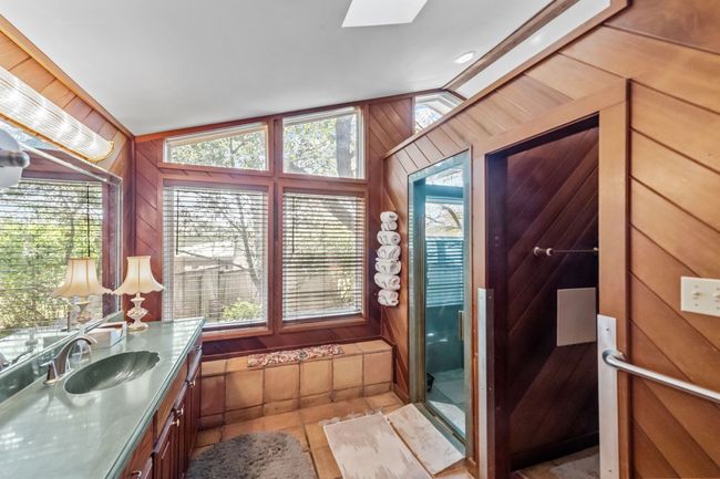 Bathroom featuring wood walls, lofted ceiling with skylight, and vanity | Image 20