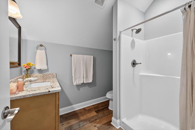 Bathroom with vanity, a shower with curtain, wood finished floors, and lofted ceiling | Image 33