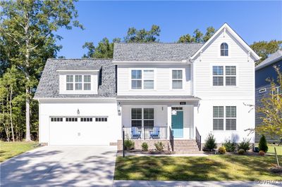 View of front of property featuring a garage, a front lawn, and covered porch | Image 1