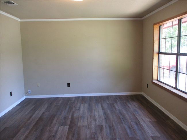Unfurnished room featuring crown molding, dark wood-type flooring, and baseboards | Image 13