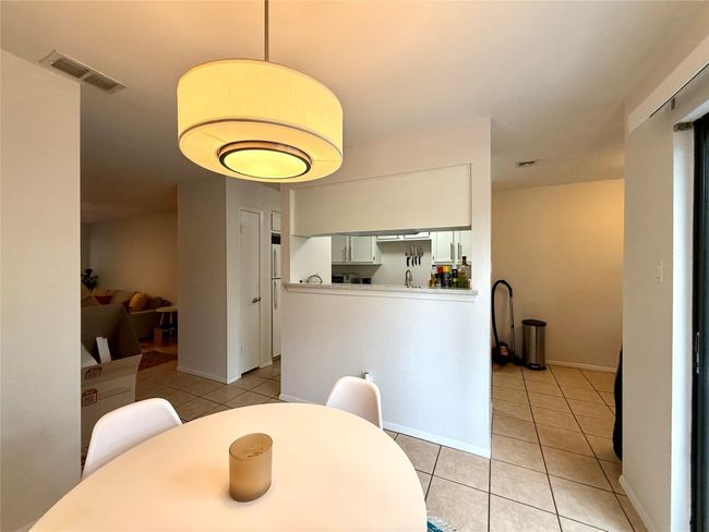 Dining area featuring light tile patterned floors and visible vents | Image 7