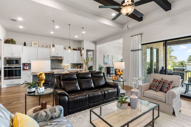 Living area featuring beam ceiling, light wood finished floors, recessed lighting, visible vents, and a ceiling fan | Image 10
