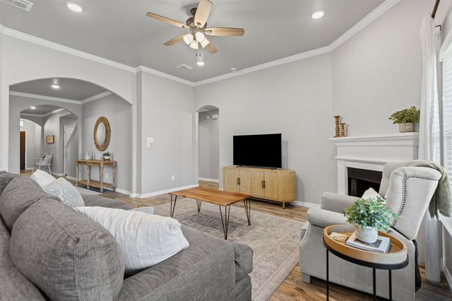 Living room featuring arched walkways, a ceiling fan, wood like tile floors, crown molding, and recessed lighting | Image 22
