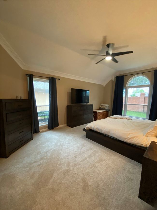 Bedroom featuring multiple windows, crown molding, carpet, and vaulted ceiling | Image 21