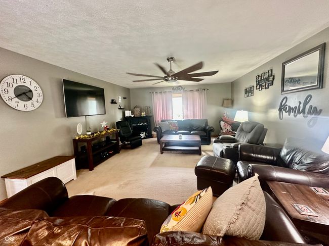 living room with light carpet and ceiling fan | Image 23
