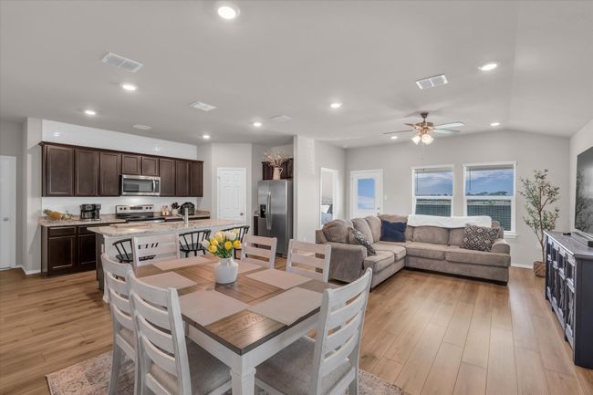 Dining space featuring light wood finished floors, recessed lighting, a ceiling fan, baseboards, and lofted ceiling | Image 18