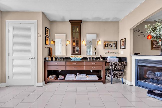 Bathroom with vanity, baseboards, and a glass covered fireplace | Image 25