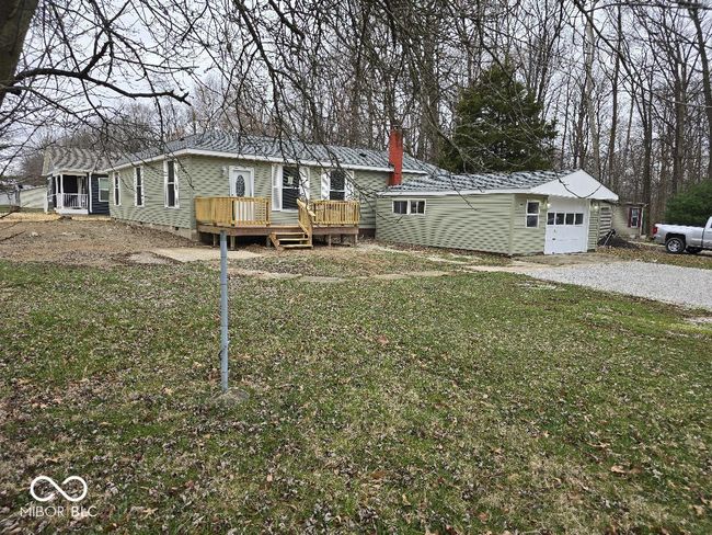 back of house with crawl space, a lawn, a chimney, and a wooden deck | Image 8