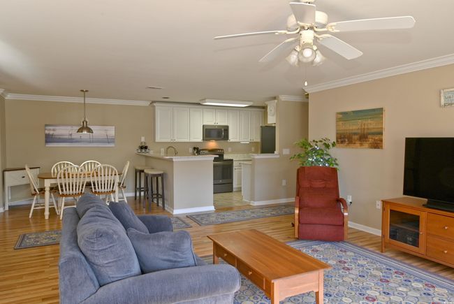Living room featuring light hardwood / wood-style flooring, ceiling fan, ornamental molding, and sink | Image 12