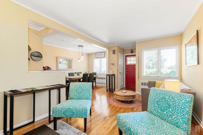 Living room featuring radiator, wood finished floors, baseboards, ornamental molding, and a chandelier | Image 4