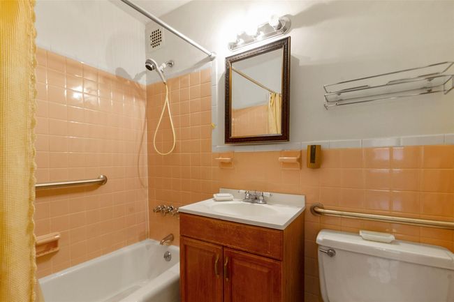 Full bath featuring shower / bathtub combination with curtain, vanity, and tile walls | Image 16