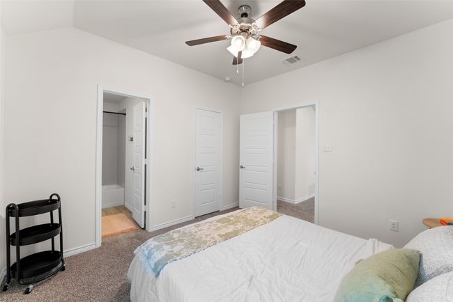 Carpeted bedroom featuring ensuite bathroom and ceiling fan | Image 25