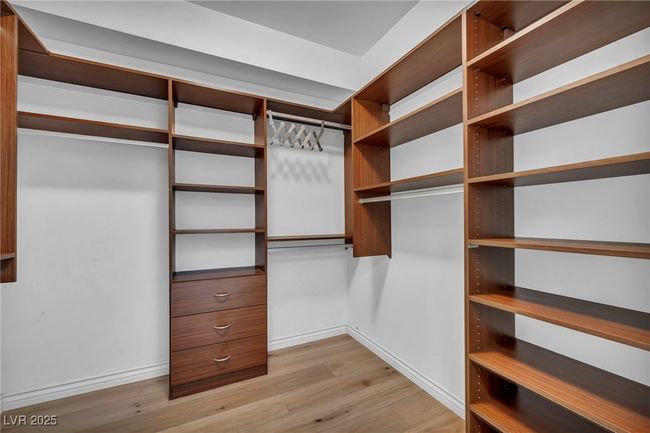 Walk in closet featuring light wood-style floors | Image 32