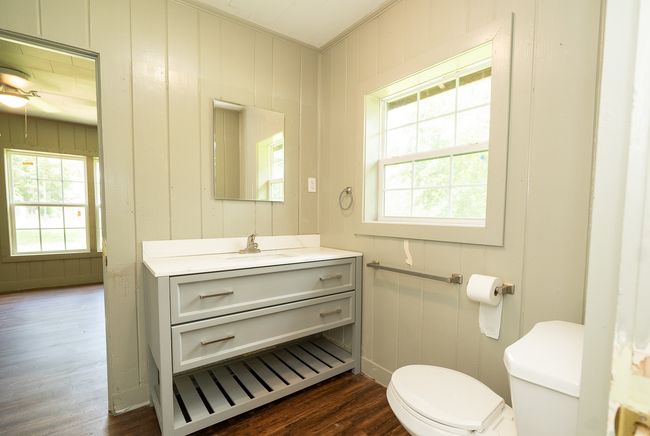 Bathroom with crown molding, vanity, wood finished floors, ceiling fan, and a decorative wall | Image 21