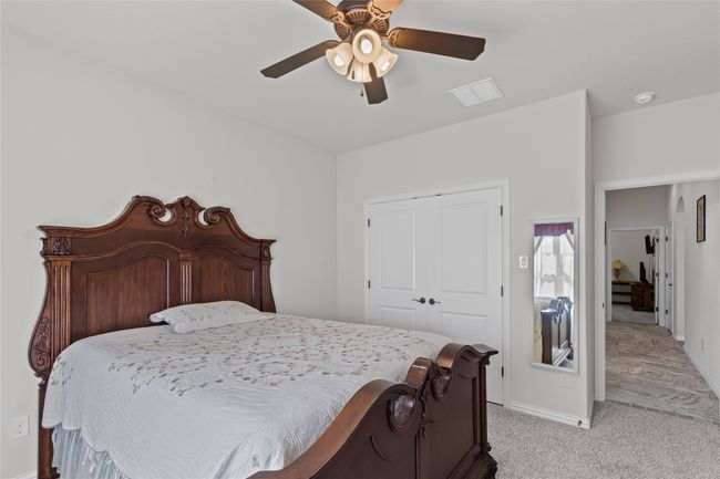 Bedroom with baseboards, a ceiling fan, a closet, and light colored carpet | Image 12