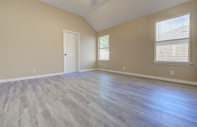Spare room with wood finished floors and vaulted ceiling | Image 13
