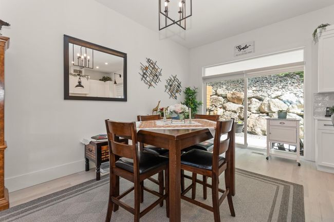Dining room with a chandelier, light wood finished floors, and baseboards | Image 8