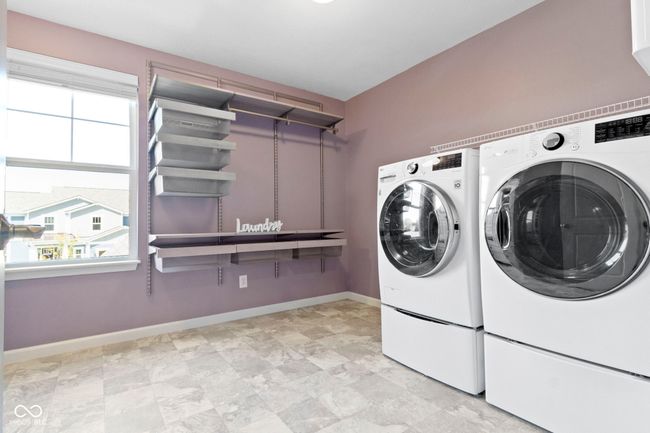 This super laundry, with included top of the line washer and dryer, has custom shelving. The washer has a small load washer in the pedestal! | Image 49
