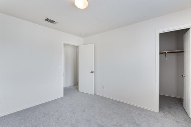 Unfurnished bedroom with light colored carpet, a spacious closet, and a closet | Image 26