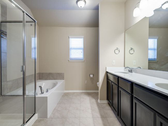 Primary bathroom featuring a garden tub, plenty of natural light, a stall shower, and tile patterned floors | Image 11