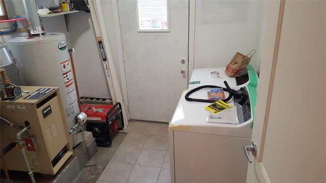 Clothes washing area with water heater, independent washer and dryer, and light tile patterned floors | Image 12