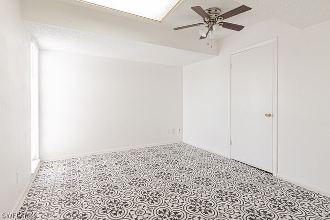 Tiled empty room featuring a textured ceiling and ceiling fan | Image 28