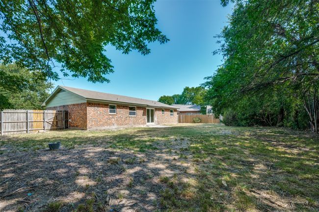 Rear view of house with a fenced backyard and brick siding | Image 21
