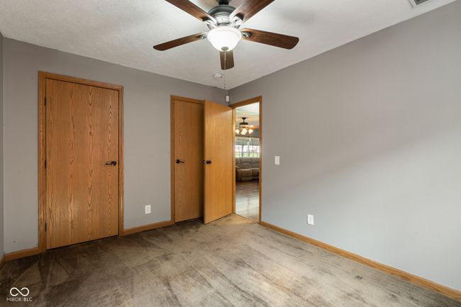 unfurnished bedroom with carpet floors, baseboards, ceiling fan, and visible vents | Image 30