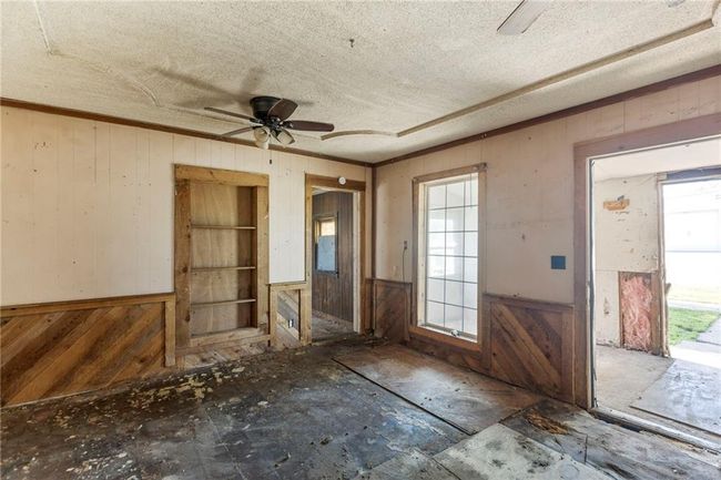 Foyer with wooden walls, a ceiling fan, and a textured ceiling | Image 5