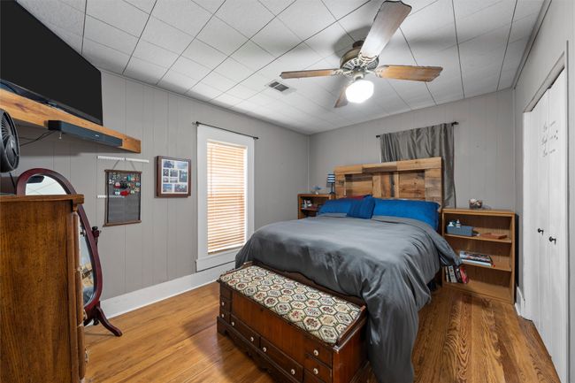 Bedroom with baseboards, visible vents, a ceiling fan, and wood finished floors | Image 10
