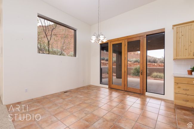 Unfurnished dining area with french doors and a notable chandelier | Image 16