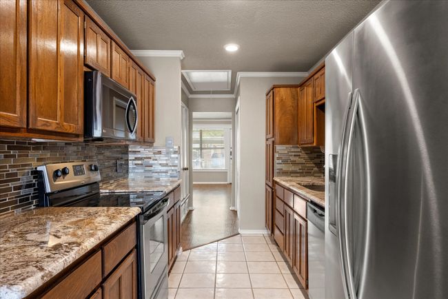 Beautiful, updated galley kitchen with stainless steel appliances and ample storage. | Image 12